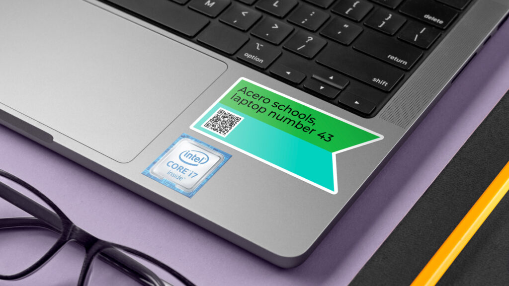 A QR Code sticker on a laptop, creatively used by Acero Schools to manage and report any issues with school laptops. 